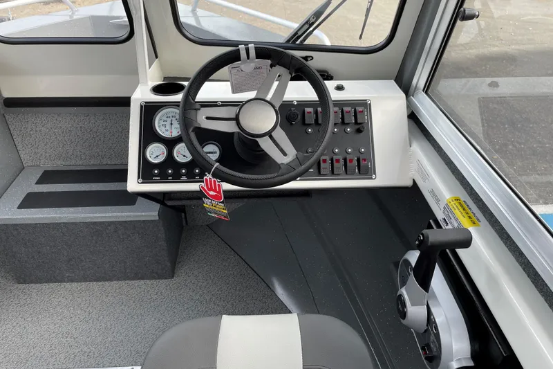 Slide: The Image of 2024 Spartan 185 Astoria boat cockpit with steering wheel and control panel. - 12