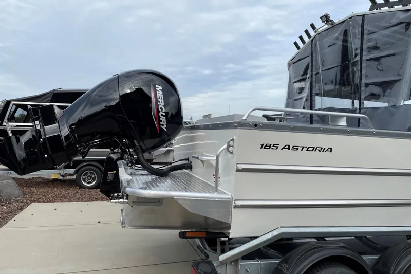 Slide: The Image of 2024 Spartan 185 Astoria boat with Mercury outboard motor, docked on a trailer. - 3
