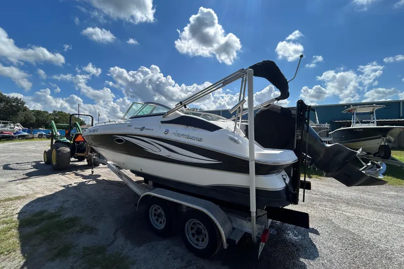 Slide: The Image of 2011 Hurricane SunDeck 2000 OB boat on trailer under a bright blue sky. - 1