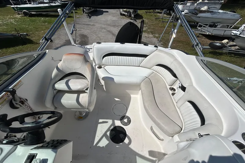 Slide: The Image of 2011 Hurricane SunDeck 2000 OB boat interior with white seating and steering console. - 10