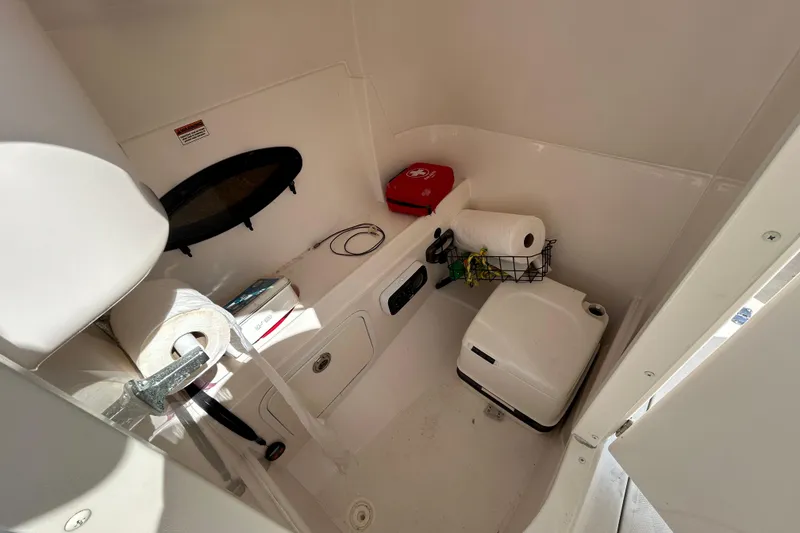 Slide: The Image of 2011 Hurricane SunDeck 2000 OB boat interior with toilet, storage, and essentials. - 12