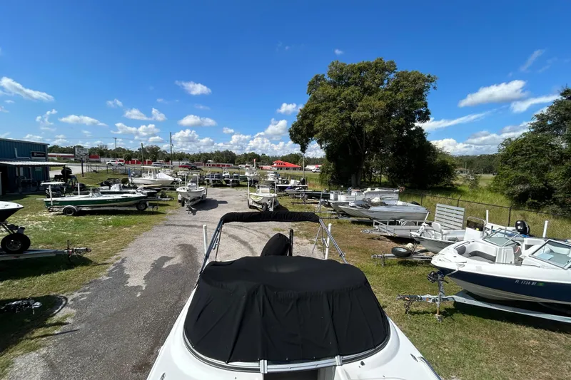 Slide: The Image of Outdoor display of various boats, featuring a 2011 Hurricane SunDeck 2000 OB under a clear blue sky. - 4