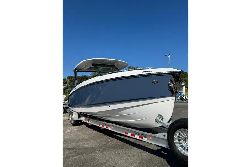 Slide: The Image of 2026 Monterey Elite 30 OB boat on trailer under clear blue sky. - 14