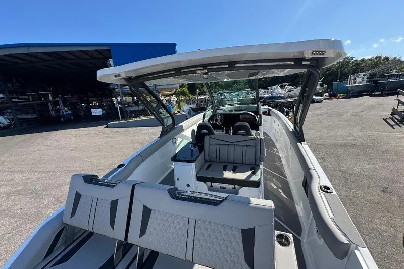 Slide: The Image of 2026 Monterey Elite 30 OB boat interior with seating and helm, docked outdoors. - 3