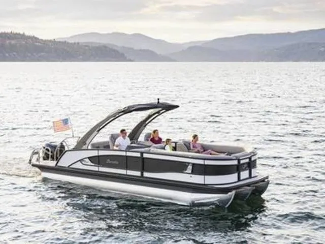 Slide: The Image of 2025 Barletta Lusso L23QCSSA pontoon boat cruising on a scenic lake. - 1