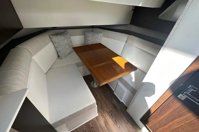 Slide: The Image of Interior of 2026 Cruisers Yachts 38 GLS OB with cozy seating and wooden table. - 11