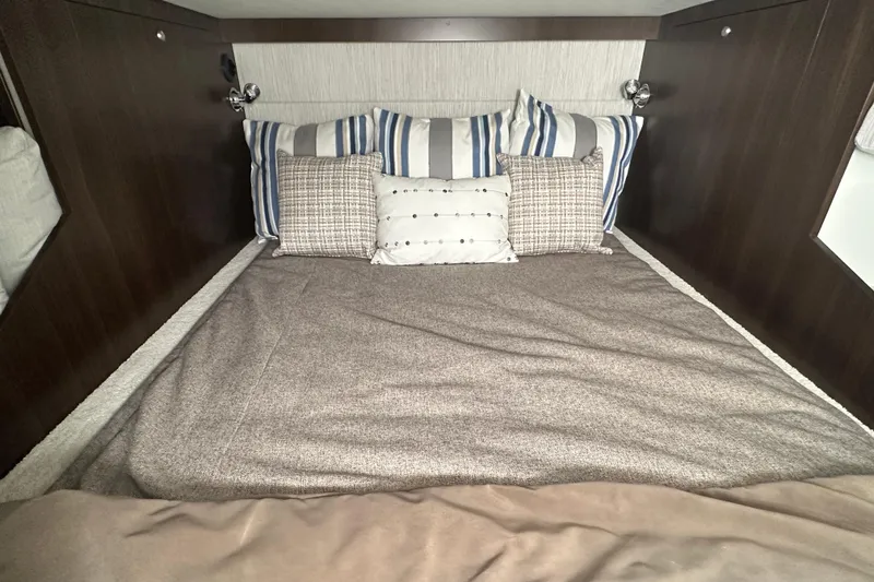 Slide: The Image of Luxurious cabin bed in 2026 Cruisers Yachts 38 GLS OB, featuring stylish pillows and cozy bedding. - 12
