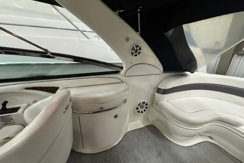 Slide: The Image of Interior of 2005 Sea Ray 290 Sun Sport boat with white seating and speakers. - 16