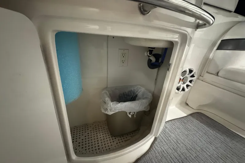 Slide: The Image of Interior storage compartment of 2005 Sea Ray 290 Sun Sport boat with trash bin. - 19