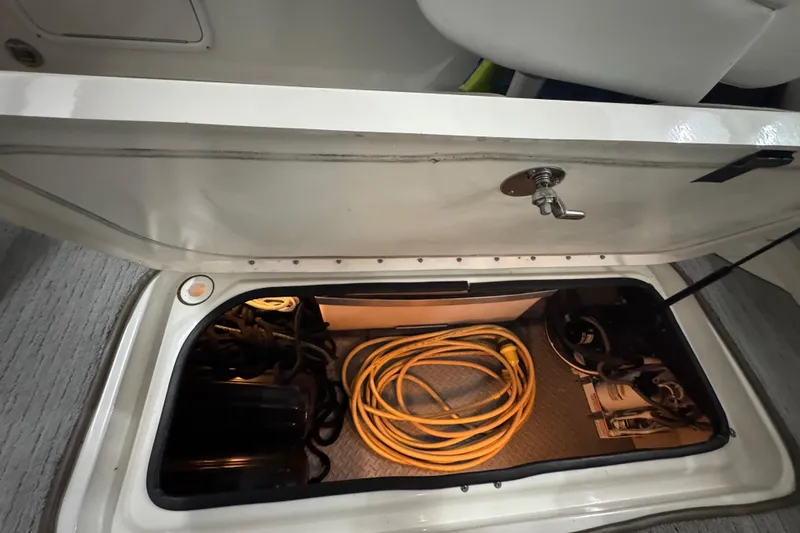 Slide: The Image of Storage compartment of 2005 Sea Ray 290 Sun Sport with coiled yellow cable. - 28