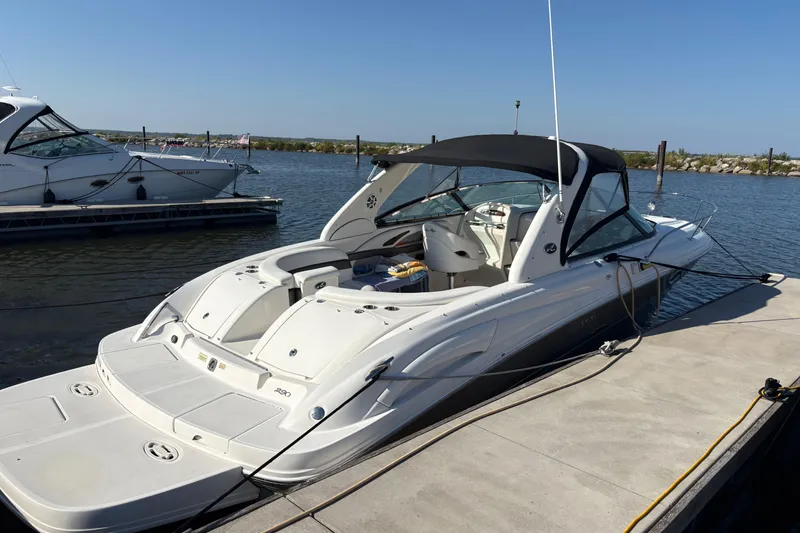 Slide: The Image of 2005 Sea Ray 290 Sun Sport boat docked at marina under clear blue sky. - 9