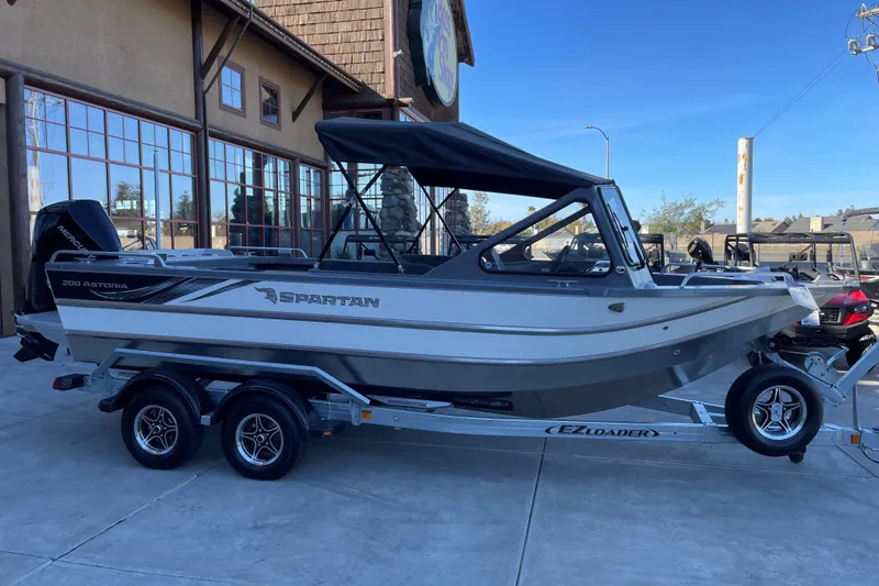 The Image of 2025 Spartan 200 Astoria boat on trailer, parked outside a building. - 1