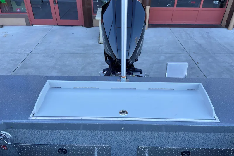 Slide: The Image of 2025 Spartan 200 Astoria boat with motor, docked near red doors. - 11