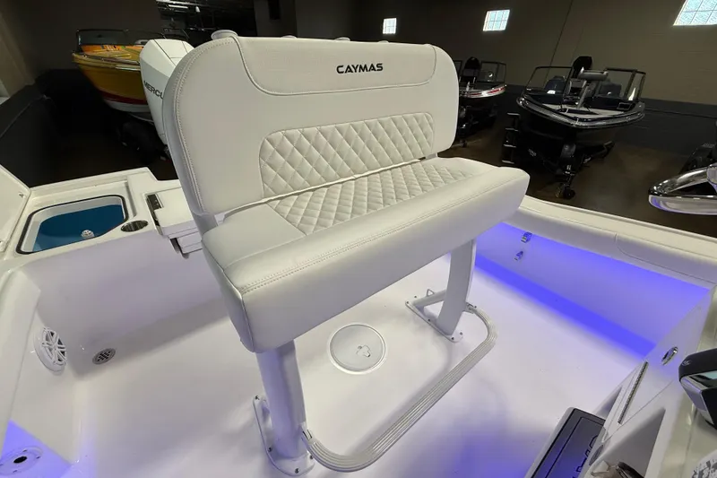 Slide: The Image of 2026 Caymas 24 HB boat interior with white cushioned seating and blue LED lighting. - 10