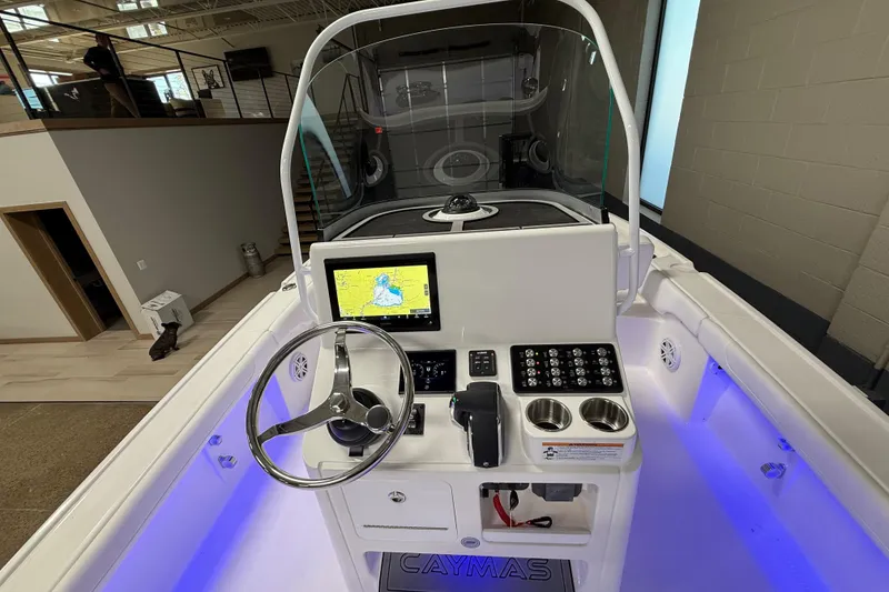 Slide: The Image of 2026 Caymas 24 HB boat dashboard with navigation screen and illuminated controls. - 12