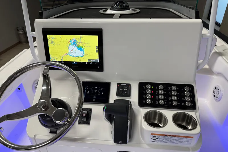 Slide: The Image of 2026 Caymas 24 HB boat dashboard with navigation screen, steering wheel, and control panel. - 13