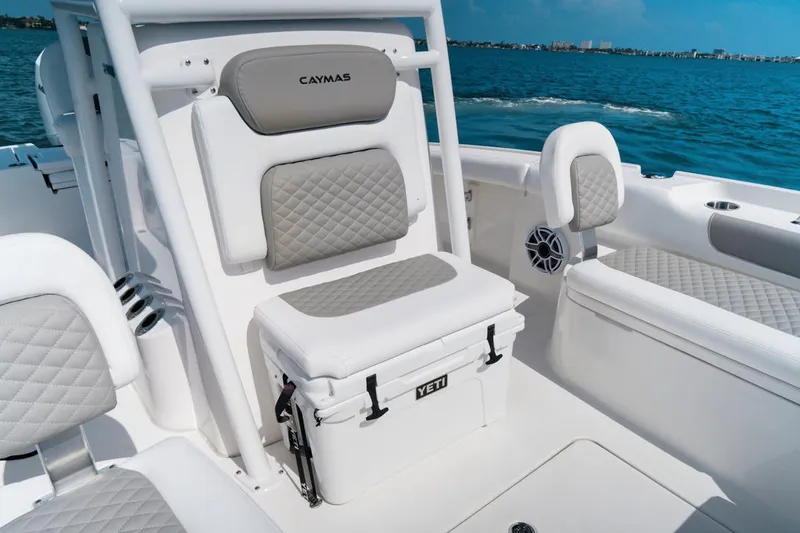 Slide: The Image of 2026 Caymas 24 HB boat interior with white cushioned seating and Yeti cooler. - 16