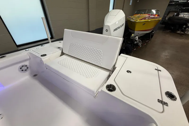 Slide: The Image of 2026 Caymas 24 HB boat interior with white seating and Mercury engine. - 8