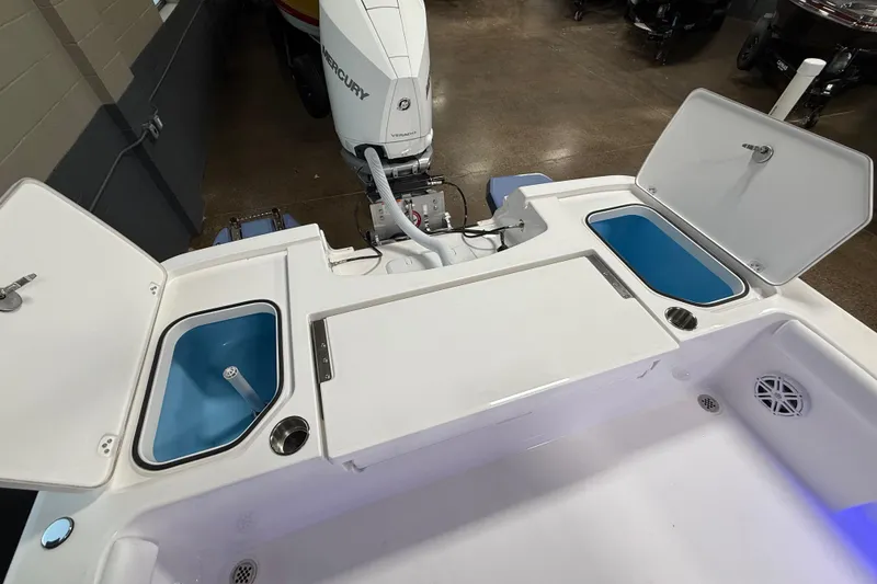 Slide: The Image of 2026 Caymas 24 HB boat interior with storage compartments and Mercury outboard engine. - 9