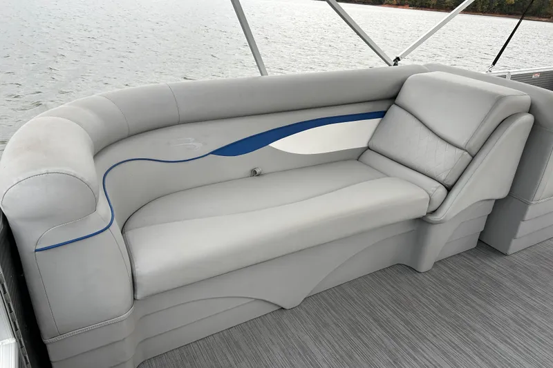 Slide: The Image of 2022 Bennington 22 SS boat interior with gray cushioned seating and blue accents. - 14