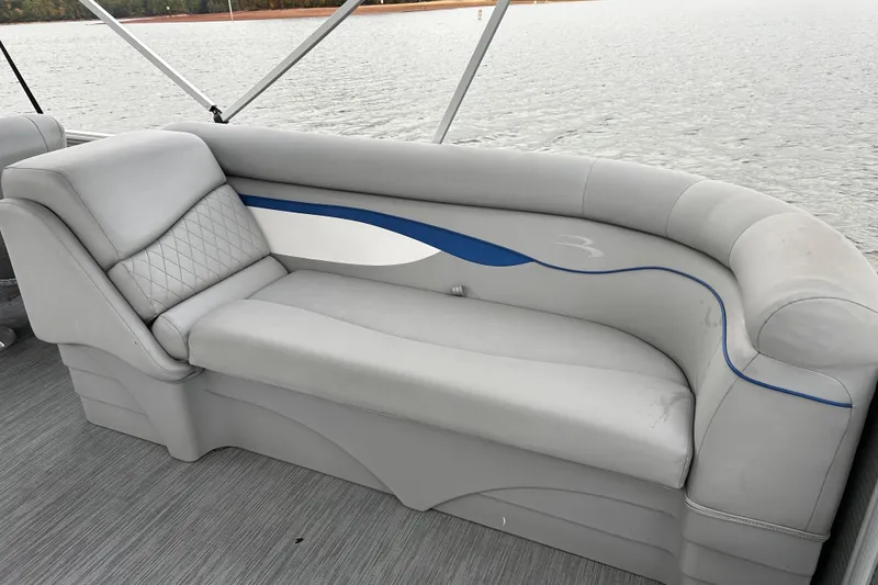 Slide: The Image of 2022 Bennington 22 SS pontoon boat with gray cushioned seating by the water. - 15