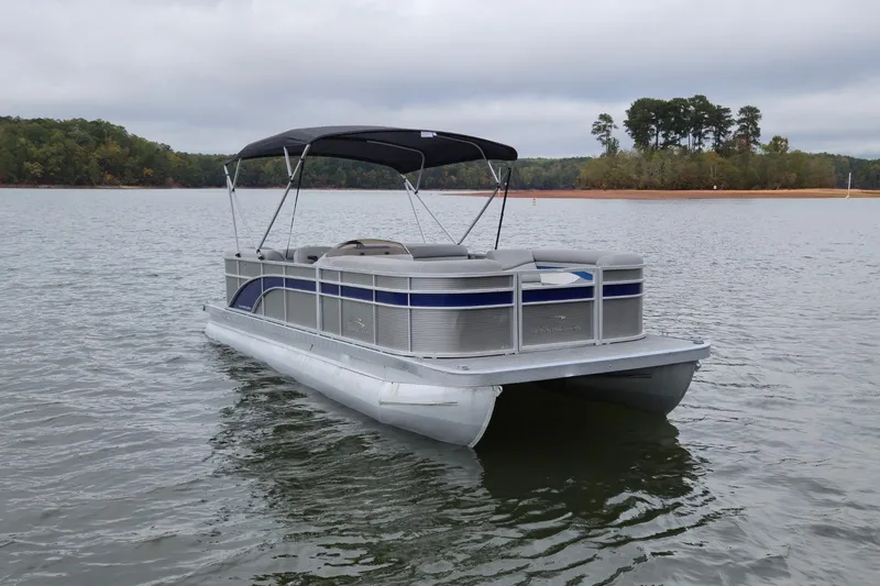 Slide: The Image of 2022 Bennington 22 SS pontoon boat on a calm lake with a canopy. - 3