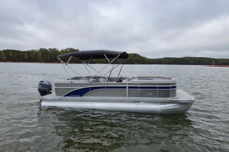 Slide: The Image of 2022 Bennington 22 SS pontoon boat on a calm lake with overcast skies. - 4