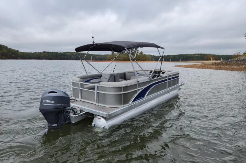 Slide: The Image of 2022 Bennington 22 SS pontoon boat on a lake with Yamaha outboard motor. - 5