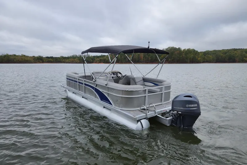 Slide: The Image of 2022 Bennington 22 SS pontoon boat on a calm lake with Yamaha outboard motor. - 7
