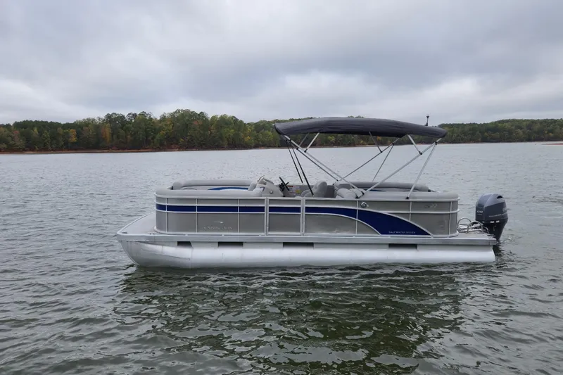 Slide: The Image of 2022 Bennington 22 SS pontoon boat on a calm lake under cloudy skies. - 8