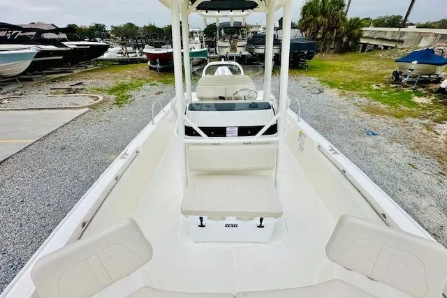 Slide: The Image of 2026 Boston Whaler 210 Montauk boat on display at a marina, showcasing seating and helm. - 20
