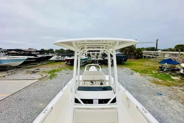 Slide: The Image of 2026 Boston Whaler 210 Montauk boat on gravel lot, surrounded by other boats. - 21