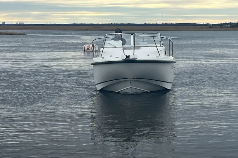 Slide: The Image of 2000 Boston Whaler 21 Conquest boat on calm water under cloudy sky. - 4