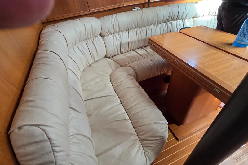 Slide: The Image of Cozy interior of 1998 Jeanneau Sun Odyssey 42 Center Cockpit with plush seating and wooden table. - 27