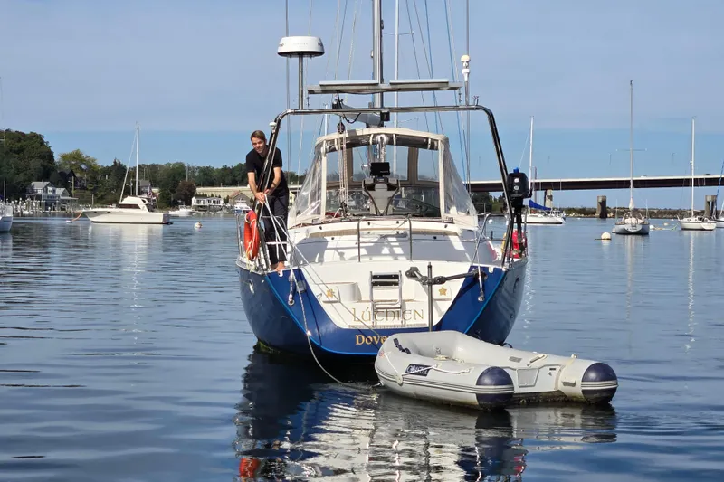 Slide: The Image of Jeanneau Sun Odyssey 42 Center Cockpit sailboat docked, 1998 model, in a scenic harbor. - 3