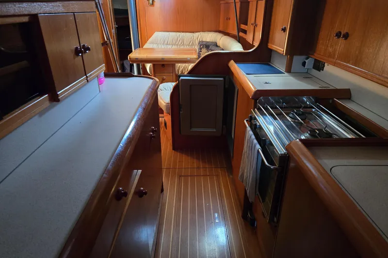 Slide: The Image of Interior of 1998 Jeanneau Sun Odyssey 42 with kitchen and seating area. - 34