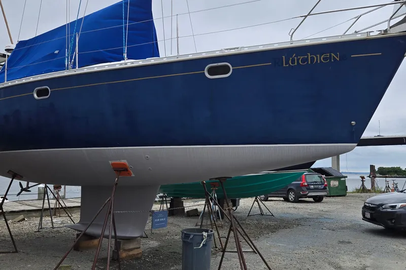 Slide: The Image of 1998 Jeanneau Sun Odyssey 42 CC sailboat on stands, blue hull, "Lúthien" name visible. - 7