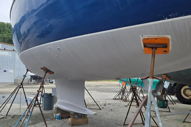 Slide: The Image of 1998 Jeanneau Sun Odyssey 42 CC sailboat on stands, hull and keel visible. - 10