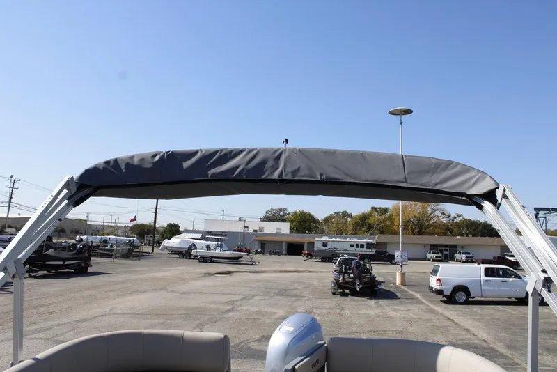 Slide: The Image of 2026 Avalon AURA QUAD LOUNGER boat with canopy in a dealership lot. - 31