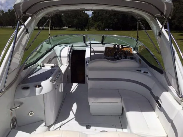 Slide: The Image of 2008 Formula 310 Sun Sport boat interior with white seating and dashboard, parked on grass. - 12