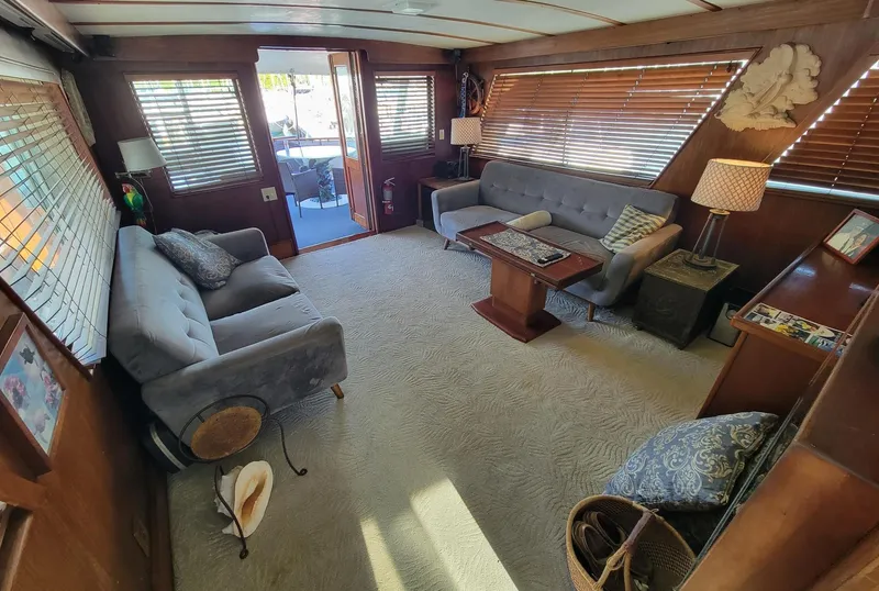 Slide: The Image of Interior of 1982 Hatteras 56 Wide Body yacht with cozy seating and wooden accents. - 10
