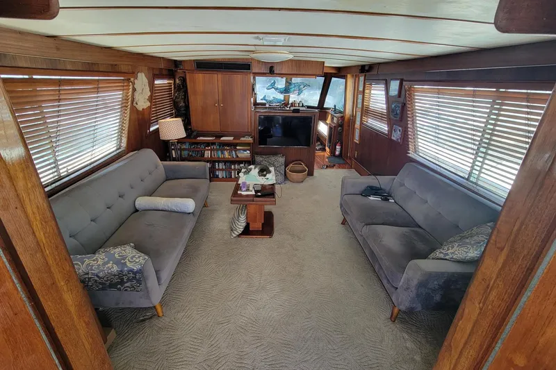 Slide: The Image of Interior of 1982 Hatteras 56 Wide Body yacht with cozy seating and wooden accents. - 11