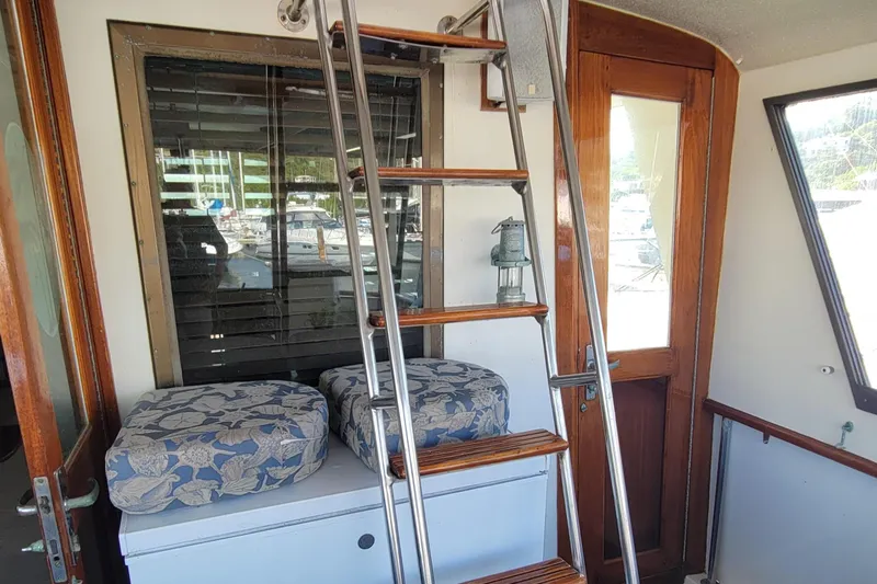 Slide: The Image of Interior of 1982 Hatteras 56 Wide Body yacht with ladder and cushioned seating. - 17