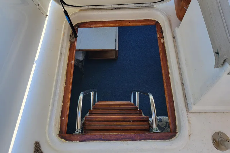 Slide: The Image of Stairway leading below deck on 1982 Hatteras 56 Wide Body yacht. - 18