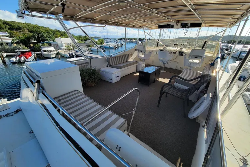 Slide: The Image of Luxurious 1982 Hatteras 56 Wide Body yacht with spacious deck and scenic marina view. - 19