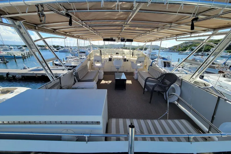 Slide: The Image of Luxurious 1982 Hatteras 56 Wide Body yacht with spacious deck and marina view. - 20