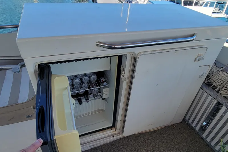 Slide: The Image of Open mini fridge on 1982 Hatteras 56 Wide Body yacht, stocked with beverages. - 26