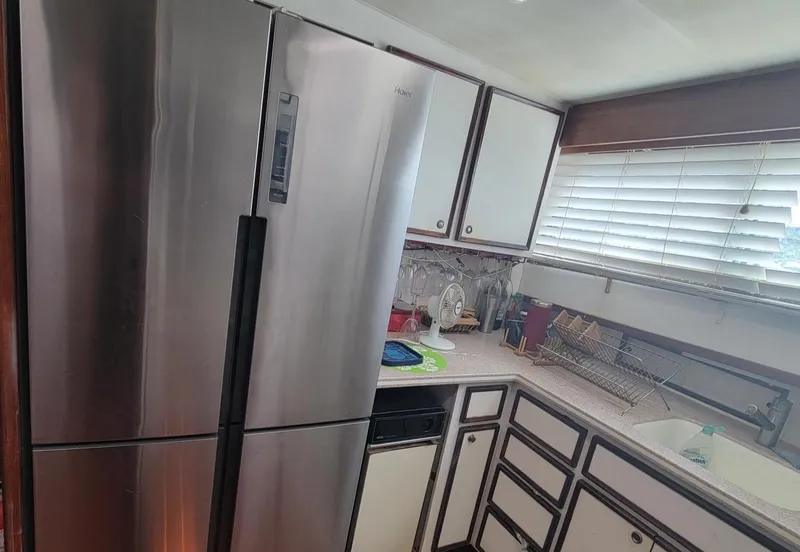 Slide: The Image of Modern kitchen inside a 1982 Hatteras 56 Wide Body yacht with stainless steel appliances. - 29
