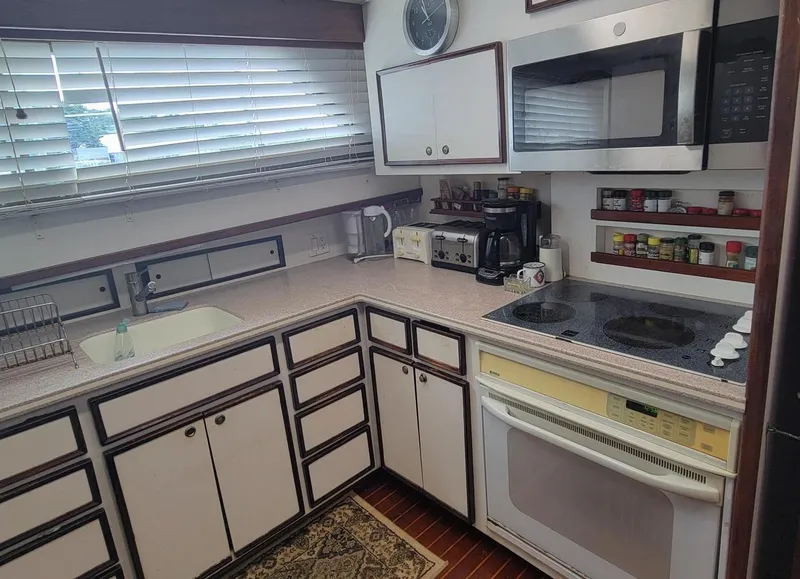 Slide: The Image of Kitchen interior of 1982 Hatteras 56 Wide Body yacht with modern appliances and cabinetry. - 30