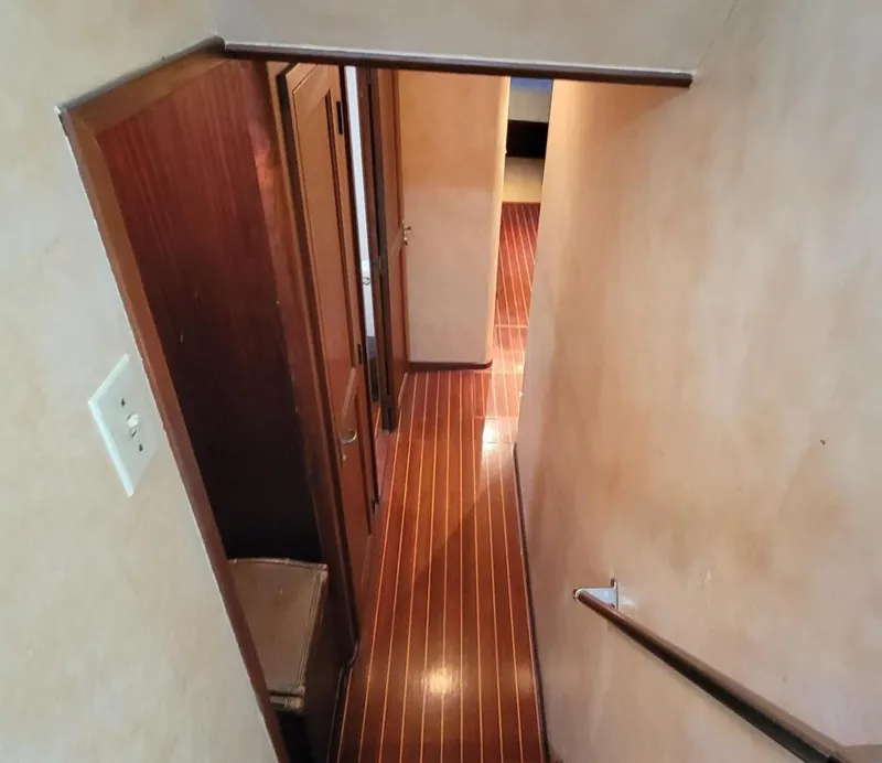 Slide: The Image of Interior view of 1982 Hatteras 56 Wide Body yacht, featuring wooden flooring and hallway. - 31